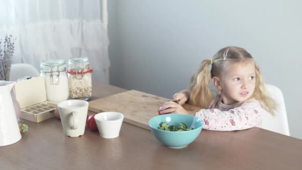 Маленькая девочка режет помидор для овощного салата — стоковое видео