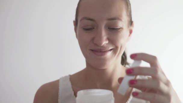 Woman applies Moisturizer face mask — Stok video