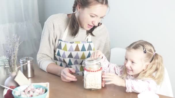 Maman montre sa petite fille flocons d'avoine — Video