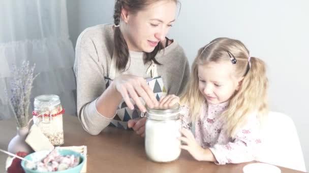 Mãe e filha cobrem um frasco de farinha — Vídeo de Stock