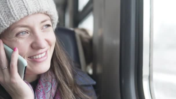 Una mujer habla en un teléfono móvil en un tren . — Vídeos de Stock