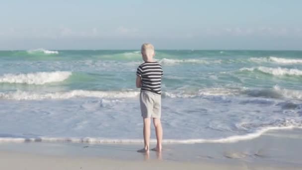 De blonde jongen verheugt zich in de vakantie op zee — Stockvideo