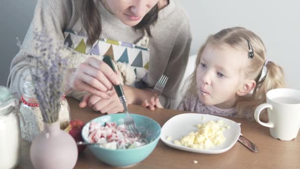 Mamá y su hija comen ensalada y tortilla en casa — Vídeos de Stock