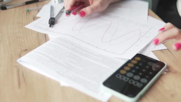 A woman at work checks the estimate on the calculator — Stock Video