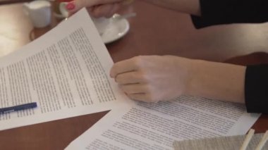 Bir iş kadını öğle yemeğinde görüşmeler için evrak hazırlar.