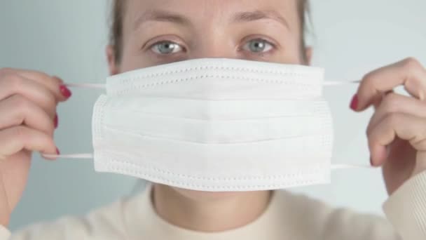 Close-up van een vrouw met een medisch masker ter bescherming tegen het coronavirus — Stockvideo