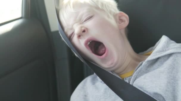 Мальчик-альбинос заснул в машине на дороге . — стоковое видео