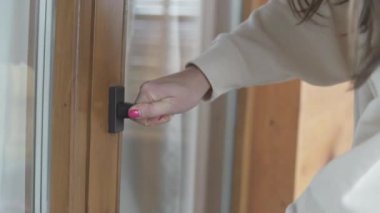 Bir kadın elinde anahtarla ön kapıyı açıyor..