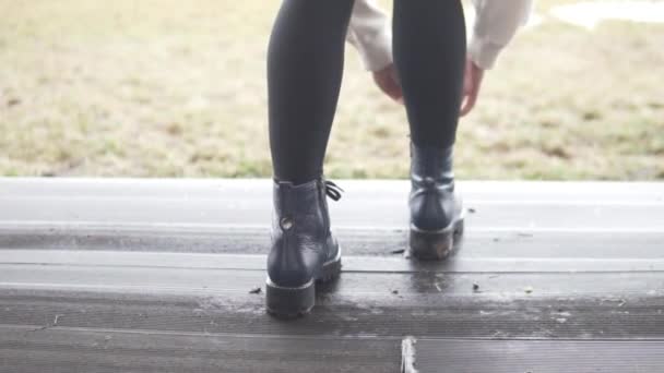Женщина завязывает шнурки на обуви — стоковое видео