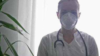 Yüzünde tıbbi maske olan kadın bir doktor hastalarla iyi anlaşır.
