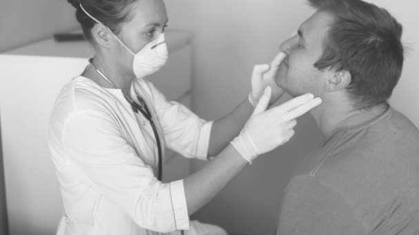 Un médico enmascarado examina a un joven enfermo . — Vídeo de stock