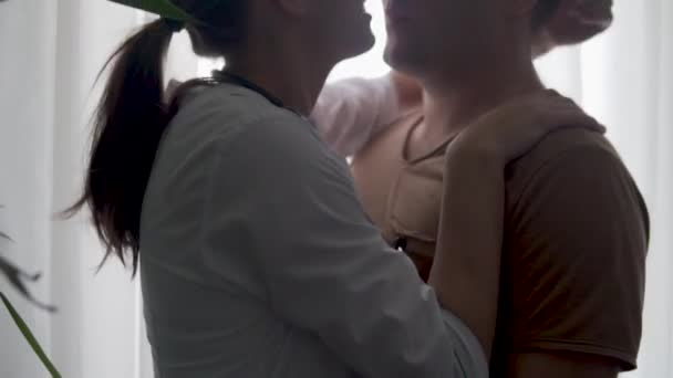 Bir kadın doktor, yorucu bir iş gününden sonra sevgilisini öper. — Stok video