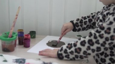 Küçük bir kız bir kağıt parçasına resim yapıyor.