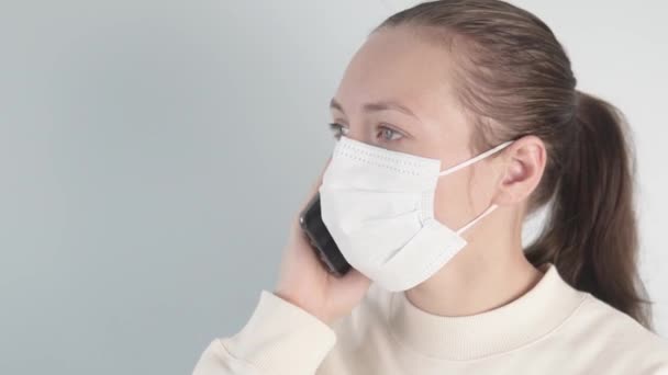 Μια γυναίκα στο τηλέφωνο φοράει ιατρική μάσκα. — Αρχείο Βίντεο