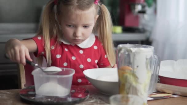 Гарна маленька дівчинка готує на кухні . — стокове відео