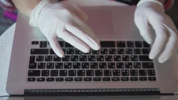 Hände in Schutzhandschuhen tippen auf den Laptop. — Stockvideo
