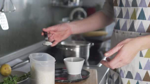 Kobieta waży ryż do zupy na kuchennej wadze. — Wideo stockowe