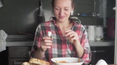 Kadın yemek yemeden önce yüzündeki tıbbi maskeyi çıkarıyor ve ellerini antiseptikle tedavi ediyor.