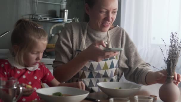 Uma mulher tira fotos de sua comida em seu telefone em casa no almoço — Vídeo de Stock