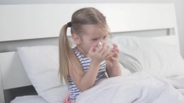 Tatlı küçük kız evde limonlu çay içiyor.