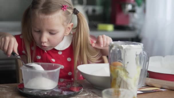 Een leuk klein meisje kookt in de keuken — Stockvideo