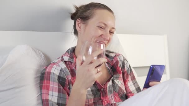 Une jeune femme boit du vin rouge avec ses amis en ligne — Video