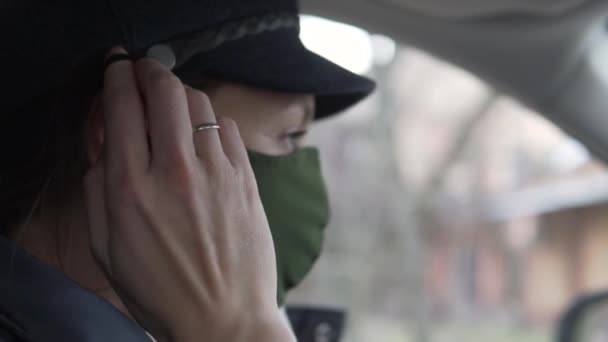 Μια γυναίκα οδηγός αυτοκινήτου βάζει μια προστατευτική μάσκα στο πρόσωπό της κατά τη διάρκεια μιας πανδημίας coronavirus — Αρχείο Βίντεο
