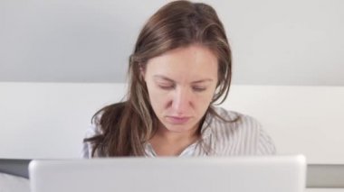 Evdeki yatakta bir kadın çalışıyor.