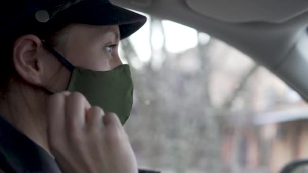 De vrouw verwijdert het beschermend masker van het gezicht in de auto — Stockvideo
