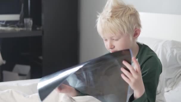 Seorang anak laki-laki pirang sedang mempelajari gambar paru-parunya setelah infeksi coronavirus — Stok Video