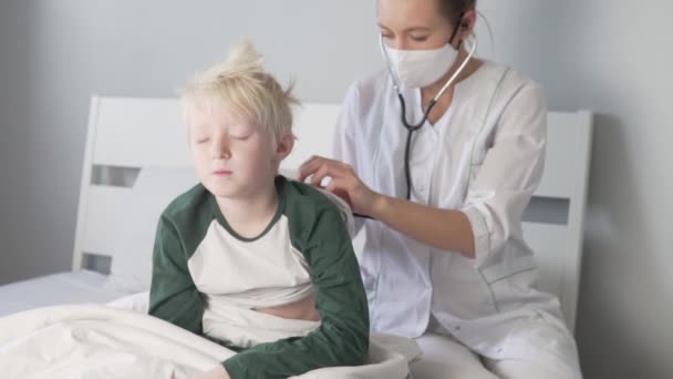 Doktorn lyssnar på ett stetoskop av ett hostande barn. — Stockvideo