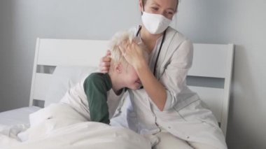 Doktor hastanede çocuğa sarılıyor.