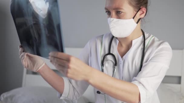 La doctora examina una instantánea de los pulmones de un paciente con coronavirus en un hospital — Vídeos de Stock