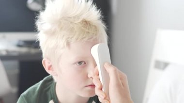 Genç beyaz çocuğun ateşi var. Sıcaklık 39 derece.