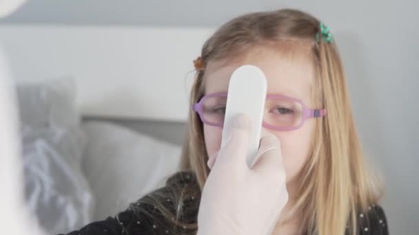 Dokter mengukur suhu seorang gadis kecil dengan termometer elektronik — Stok Video