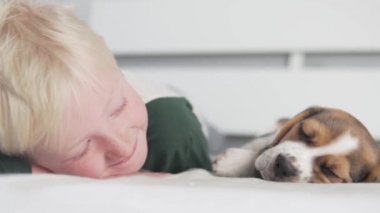 Çocuk nazikçe küçük bir köpeği okşar.