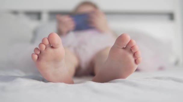 A close-up of the little girls feet in bed for three years — Stock Video