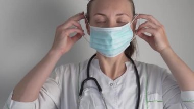 Kadın bir doktor yüzüne koruyucu bir maske takıyor.. 