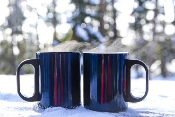 Blue mugs with a hot drink soar in the cold, winter day, picnic, Finland