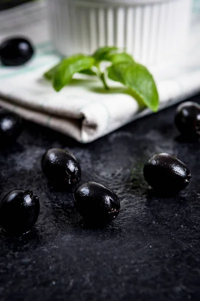 Black olives on black stone — Stock Photo, Image