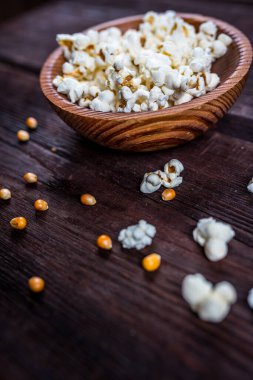 Tahta tabakta patlamış mısır ya da koyu ahşap masada kase