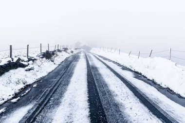 Kısmen kapalı yolun sonunda, Kuzey Batı İngiltere'de yoğun bir sis ile kar.