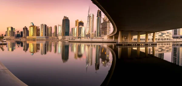 Dubai downtown at day reflected in water.