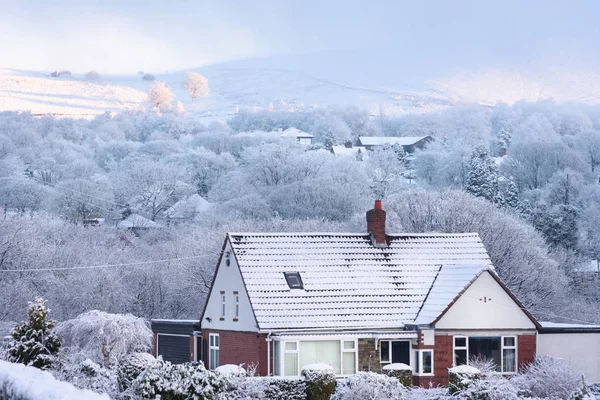 House covered by snow presenting winter dreamland in the british countryside.