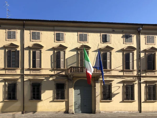 两面飘扬的意大利和Eu国旗 蓝天上有窗户和百叶窗的大楼 古老的木门 — 图库照片