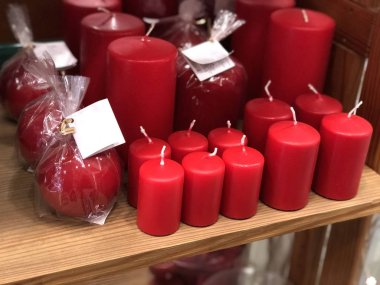 Ahşap rafta farklı şekillerde kırmızı ev mumları. Spa mı? Rahat bir ev. İç tasarım