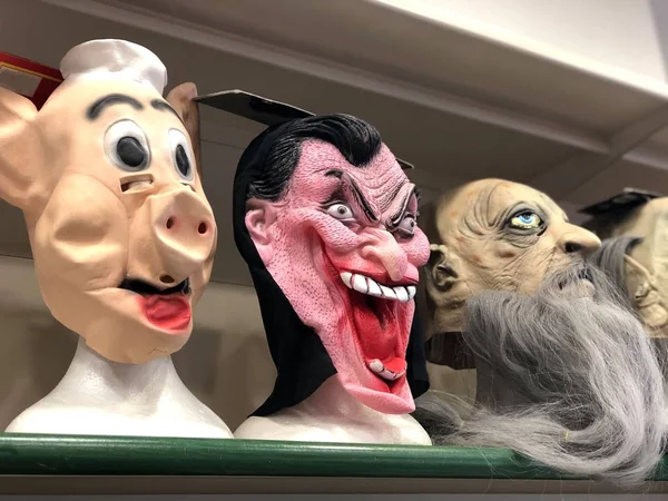 Dehşet verici karnaval maskesi mağazada. Vampir, domuz ve zombi maskeleri. Cadılar Bayramı, karnaval, maskeli balo kostümleri.