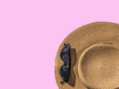 Pembe arka planda hasır şapka ve güneş gözlüğü. Yaz mankeni. Boşluğu kopyala. 