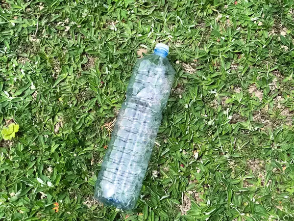 empty plastic bottle close-up on green grass top view. Plastic garbage. Recycling. Ecological situation. Separation trash
