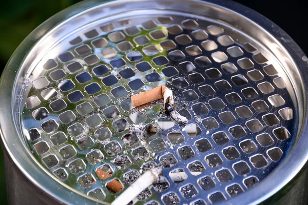 Cigarettes in outdoors ashtray, closeup — Stock Photo, Image